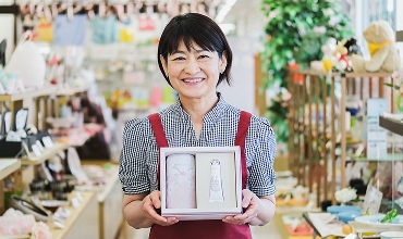 商品をこちらに見せているスタッフの写真